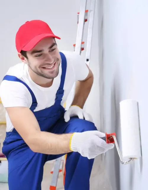 Painter in red cap painting interior wall